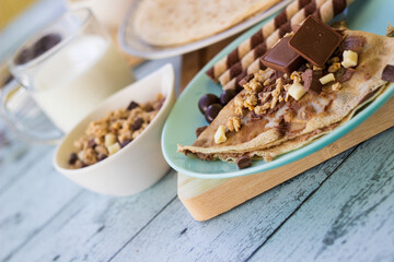 Crepes with chocolate on cutting board with ingredients