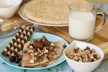 Crepes with chocolate on cutting board with ingredients