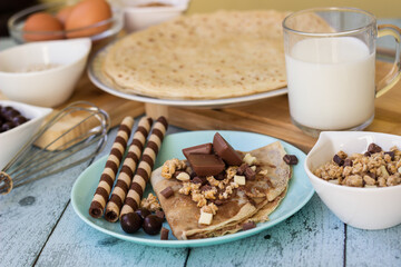 Crepes with chocolate on cutting board with ingredients