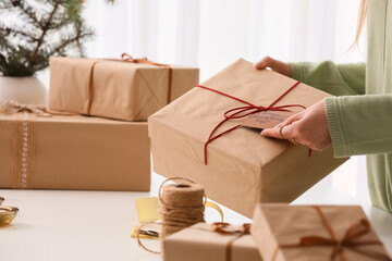 Woman with Christmas gift box at table, closeup