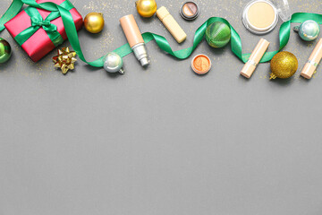 Makeup products with Christmas decor on dark background