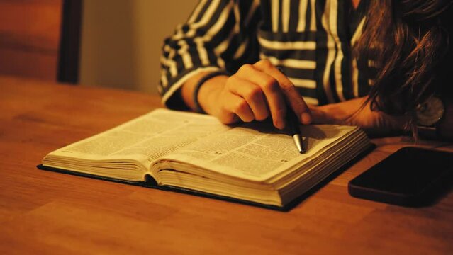 Woman Reading Scripture, Bible , God's word. Learning and reading a book. Young female reading, using a pen, reaing line by line. Christian faith. Jesus Christ 