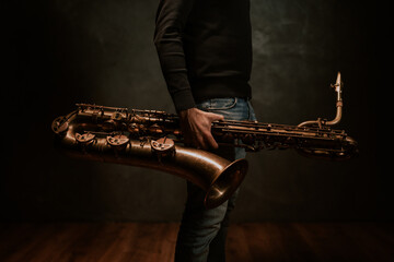 person with saxophone, saxophone in hands, music
