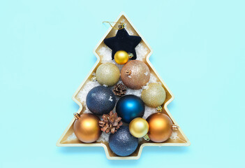 Plate in shape of Christmas tree with balls on blue background