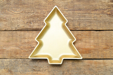 Beautiful plate in shape of Christmas tree on wooden background