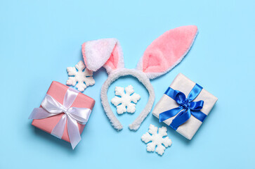 Bunny ears with Christmas gifts and snowflakes on blue background
