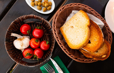 Crispy toasted white bread, fresh ripe tomatoes, garlic and pickled olives served in wicker plates....