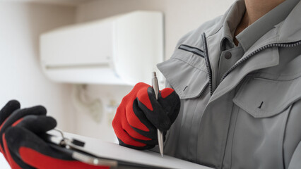 エアコンの掃除・点検をする作業服の男性｜見積イメージ