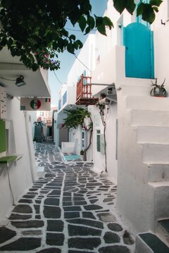 Beautiful narrow street with white houses in Naousa, Paros