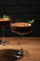 Dessert bowls of delicious hot chocolate with hazelnuts and fresh mint on wooden table