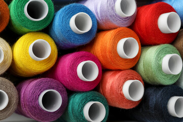 Top view of colorful sewing threads as background, closeup