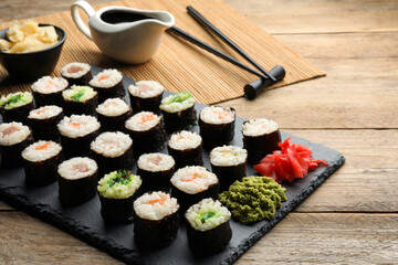 Tasty sushi rolls served on wooden table