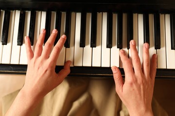 Young woman playing piano, above view. Music lesson