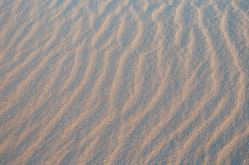 Closeup of sand pattern of a beach in the summer.