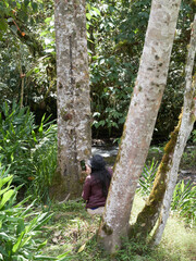 woman sitting in the forest taking a selfie