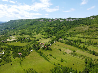 Beautiful green hills, fields and forest in early spring. Aerial drone shots of nature in countryside. 