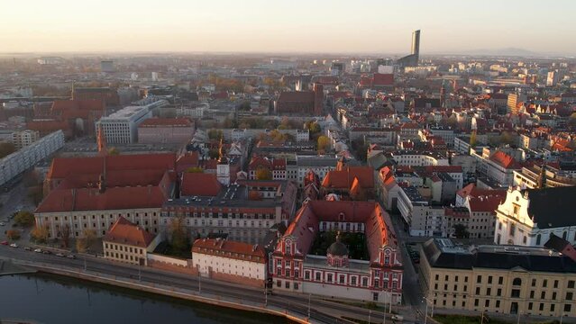 Aerial flight over odra river with island and Krasnal Ossolinek Building, national library during sunset in Wroclaw City,Poland