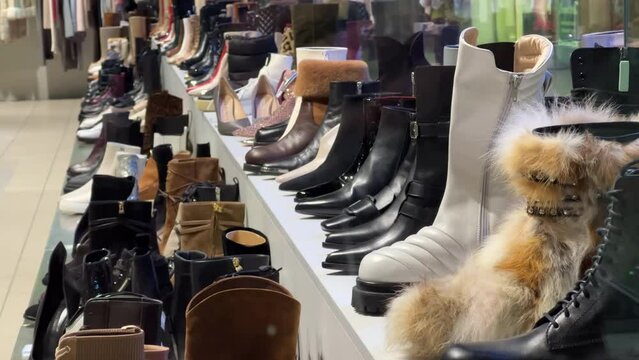 Women's various boots stand on the showcase of a shoe store