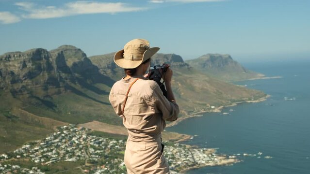 woman tourist takes a photo high in the mountains. Table Mountain and 12 Apostles from Lion's Head. Cape Town. South Africa. Table Mountain and the Twelve Apostles mountain range seen from Lion's Head
