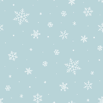 Snowy winter seamless pattern of hand drawn snow flakes on light blue background