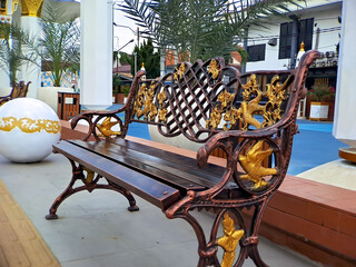 brown gold iron carving bench with arabic architecture in madiun indonesia park, sunny weather.
