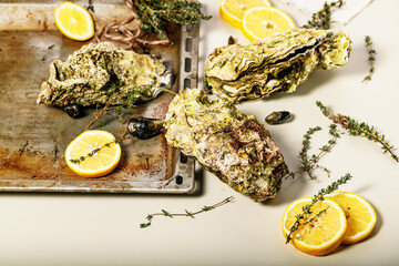 Giant fresh Pacific oysters on a light background. Lemon and oregano. Selective focus. Copy space