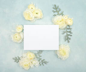 Obraz na płótnie Canvas Blank bridal stationery invitation card with fresh ranunculus blooms on light blue background