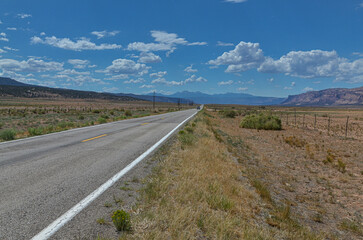 State Highway 90 passing Paradox Valley with La Sal mountains at the background (Montrose County, Colorado, USA)