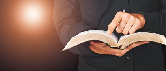 Young man holding bible book on sun light.