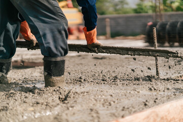 Selective focus, Construction worker leveling concrete floor with trowel. Worker pouring concrete slab.