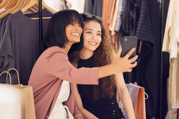 Women, friends and phone selfie while shopping in store for luxury and designer clothing. Retail,...