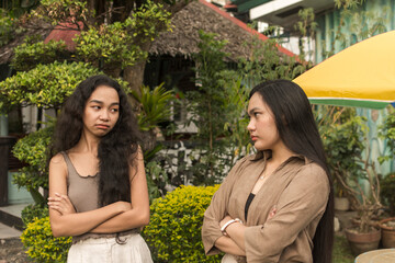 Two women not on speaking terms, mad at each other after an argument. Bad blood and animosity...