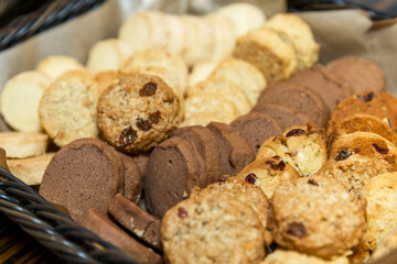 Round mouth-watering cookies in a basket on the table. Close-up. Breakfast and coffee break.