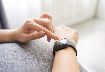 Young woman using smartwatch on her wrist