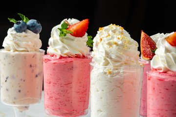 Large collection of mousse desserts in glasses for catering