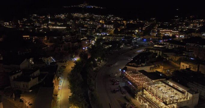 G&ouml;reme Turkey Aerial v16 low birds eye view, flyover touristic village along m&uuml;ze caddesi capturing illuminated restaurants and stores in town center at night - Shot with Mavic 3 Cine - July 2022