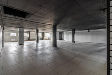 Empty retail space with a black ceiling and a dirty floor, immediately after repair