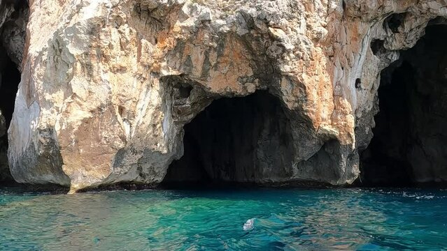 Sideways boat point of view of Vedusella or Verdusella caves on Adriatic side of Mediterranean sea, Italy. Slow motion