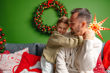 Young dad and his son celebrate Christmas together at home