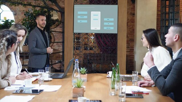 Developer presenting interface mobile app on digital board in meeting at modern office.Creative digital development mobile app team