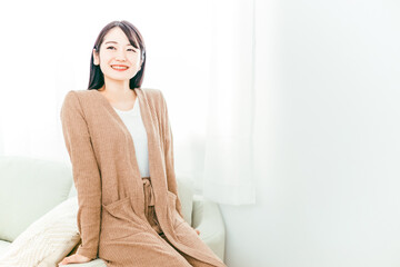 ソファのヘリに座る女性（同棲）
