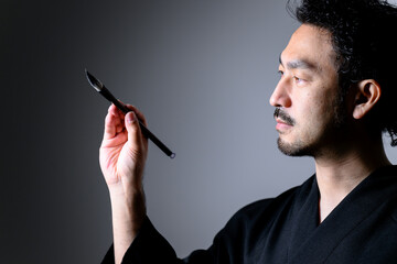 Image like a Japanese calligrapher 「shodo」holding a brush.