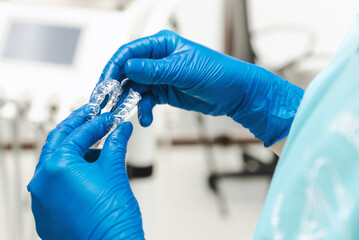 Close up photo of dentist holding invisible aligners