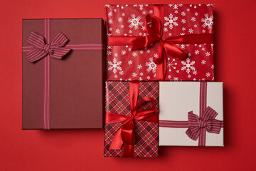 Group of gift boxes with red ribbon on red background.