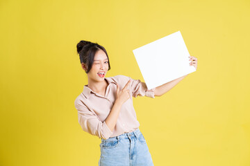 Fototapeta na wymiar image of a pretty asian girl holding a white billboard