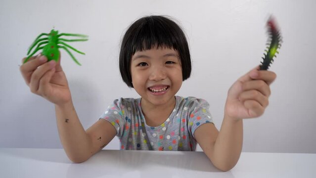 Naughty girl hold the centipede and green spider and then prank throw toward camera