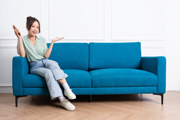 Obraz premium image of young Asian girl sitting on sofa at home