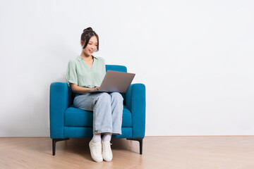 image of young Asian girl sitting on sofa at home