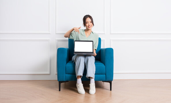 image of young Asian girl sitting on sofa at home