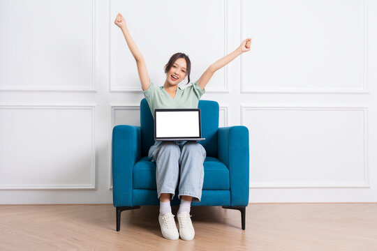 image of young Asian girl sitting on sofa at home